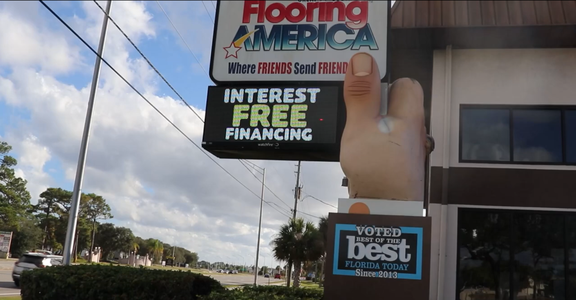 Southeast Flooring America showroom exterior with a palm tree and sun graphic on the side.