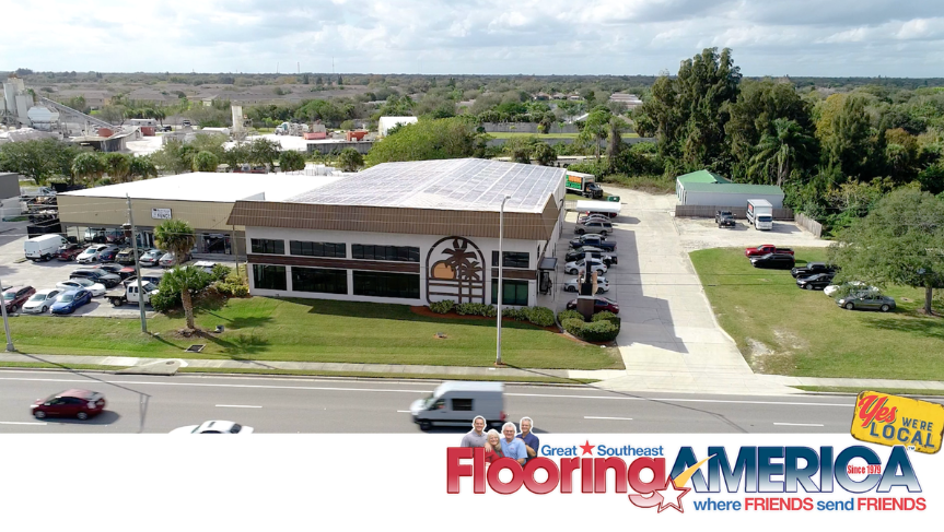 Southeast Flooring America showroom exterior with a palm tree and sun graphic on the side.